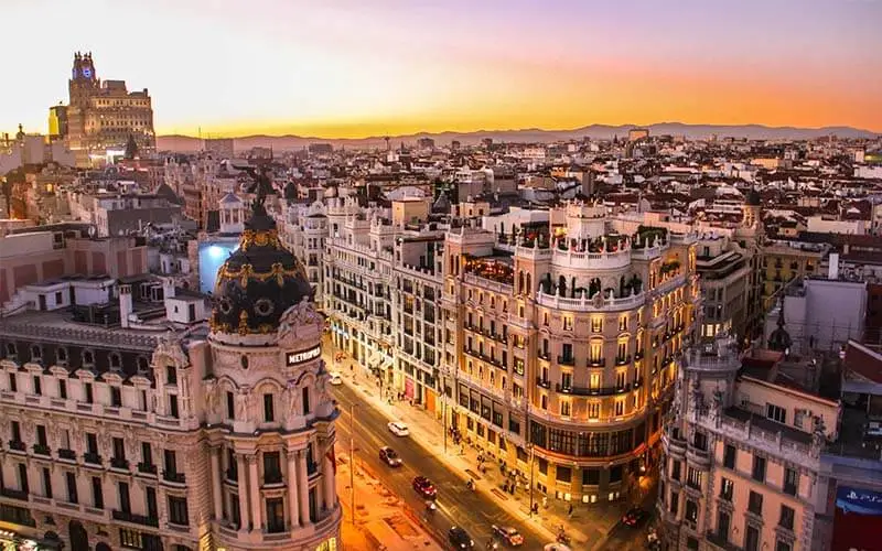 Vista panorámica de la Gran Vía de Madrid iluminada al atardecer.